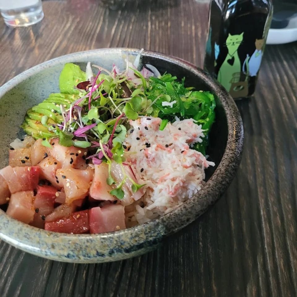 A Poke Box Sushi Bar poke bowl with tuna, crab, avocado, seaweed, and microgreens.